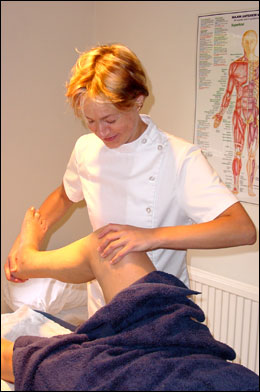 Emily Alexander examining the knee joint of a female patient at the Backworking Osteopathic Practice in Barnsbury, Islington, London N1